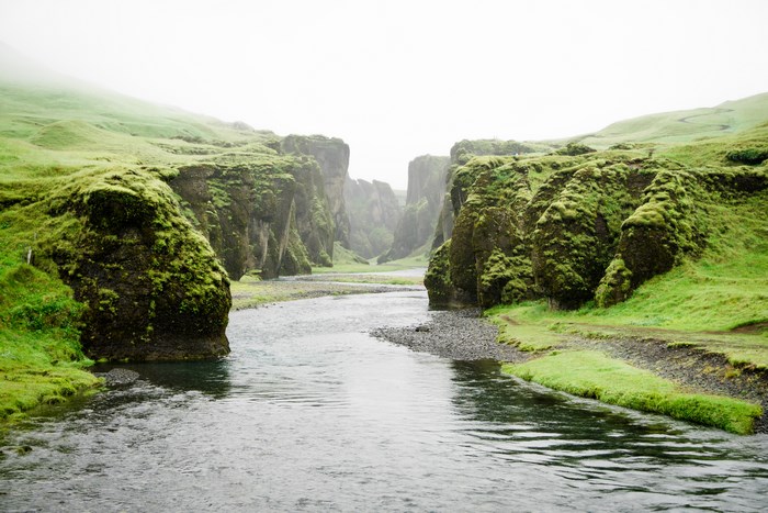 Green canyon with a river and fog