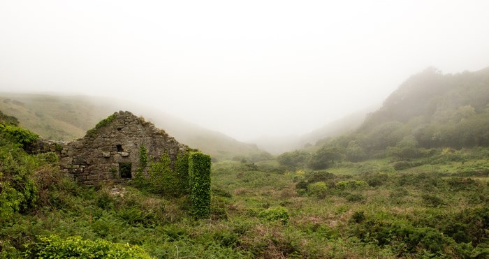 Abandoned stone ruin in a foggy valley