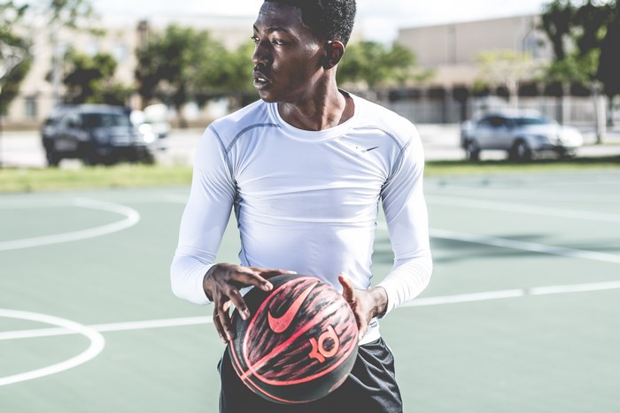 Man holding a Nike basketball on a court