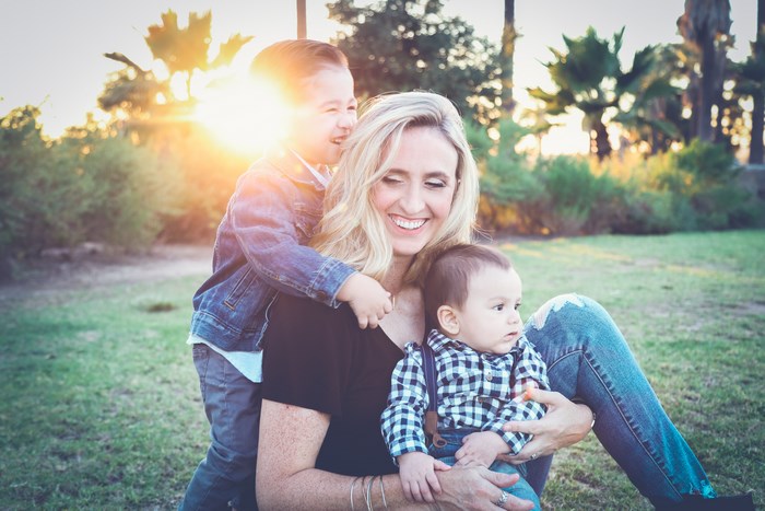 Mother and two sons in a park at sunset