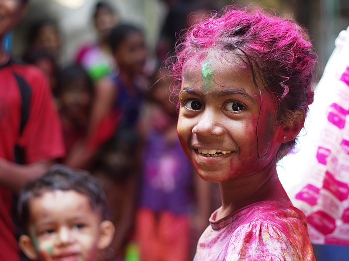 Girl with pink hair and face paint smiling