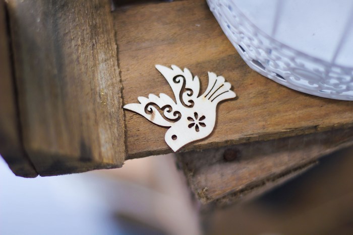 Wooden dove ornament on a wooden surface