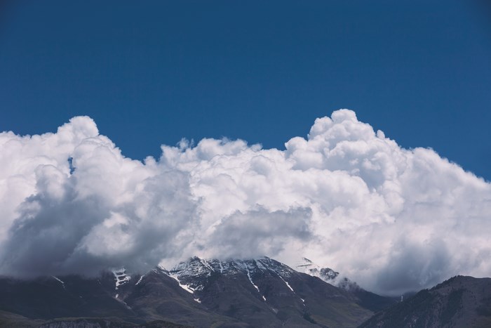 Snow-capped mountains under a blue sky with clouds