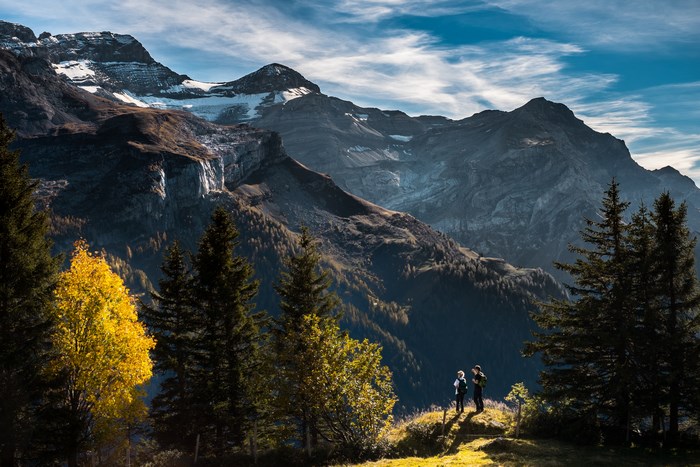 Two hikers admire a majestic mountain range