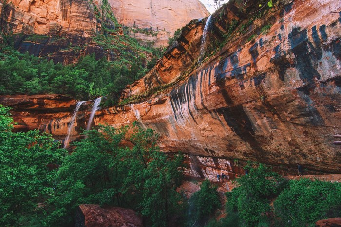 Waterfalls cascade over red rock cliffs in Zion National Park