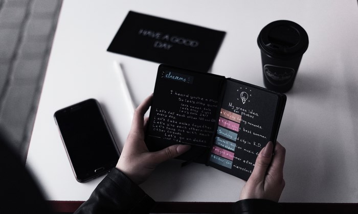 Person holding a notebook with dreams and ideas