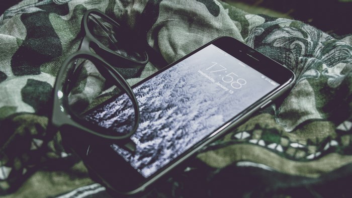 iPhone and glasses on camouflage fabric