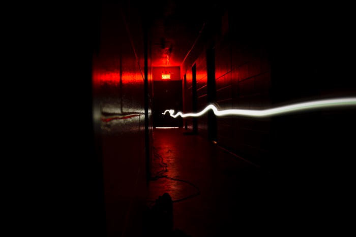 Light trail in a dark hallway with exit sign