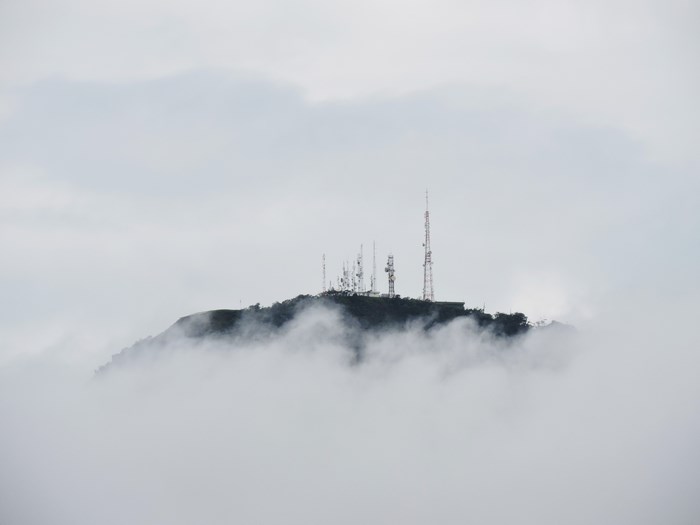 Mountain peak with communication towers in fog