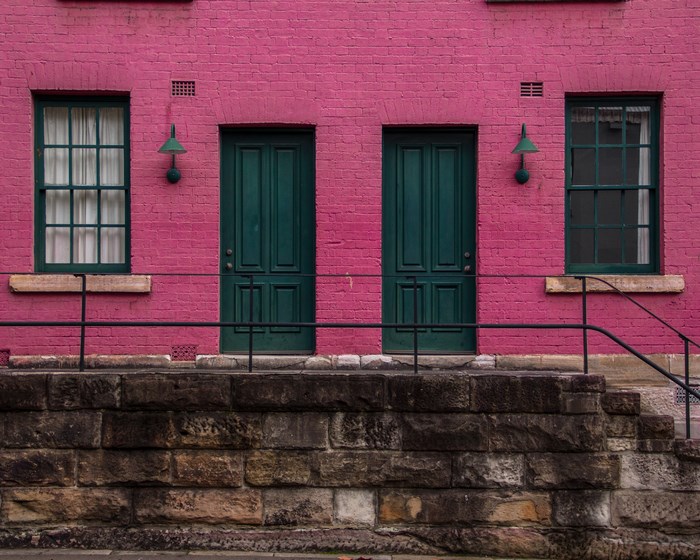 Pink brick building with green doors and windows in Sydney