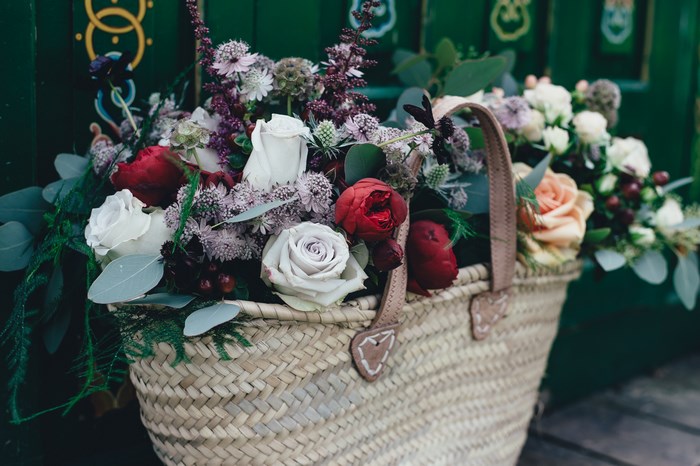 Flower bouquet in a straw basket on a doorstep