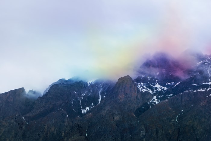 Mountain range with colorful mist and snow