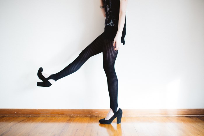 Woman in black tights and heels kicking