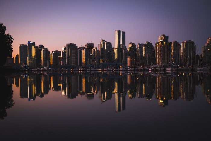 Vancouver city skyline at sunrise with water reflection