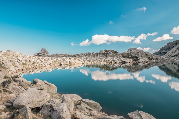 Lake reflection in Corsica, France with rocky mountains