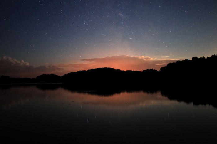 Night sky with stars reflected in a lake