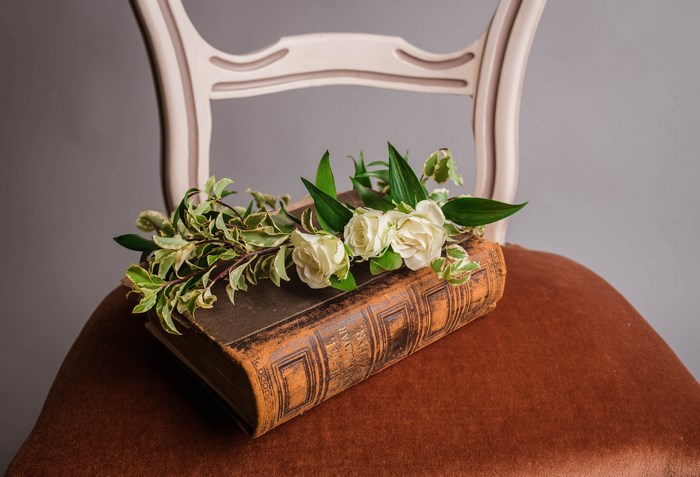 Vintage book with roses and greenery on a chair