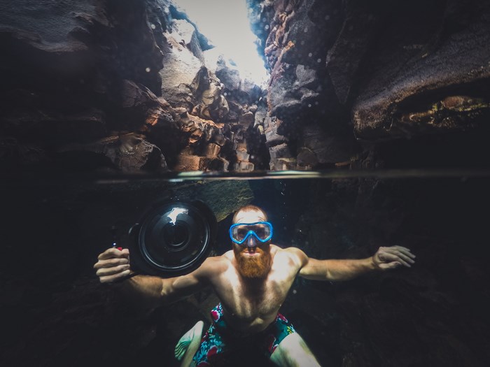 Man with beard and camera underwater in a cave