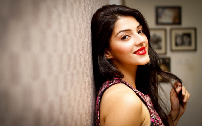 Mehreen Pirzada leaning against a textured wall