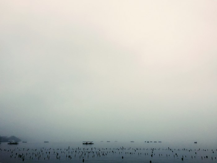 Boats and posts in a foggy sea