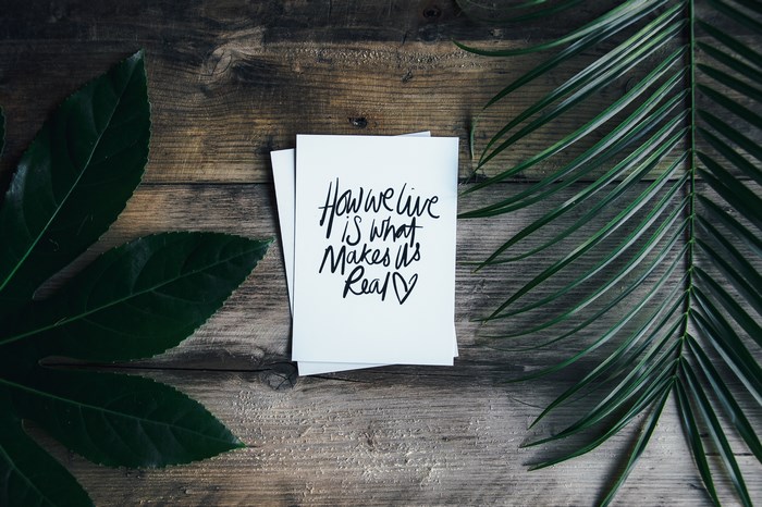 Quote on a card with leaves on a wooden table