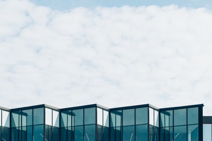Modern glass building against a cloudy sky