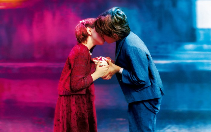 Young Couple Sharing a Tender Kiss Holding a Gift