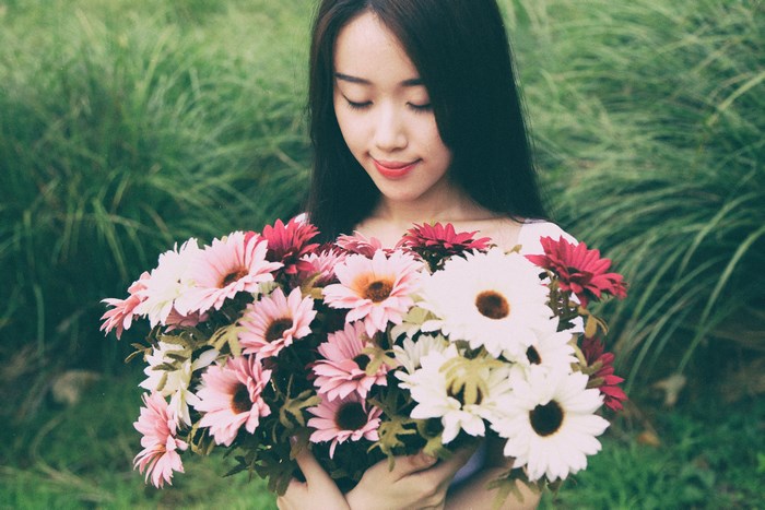 Asian woman holding a bouquet of flowers