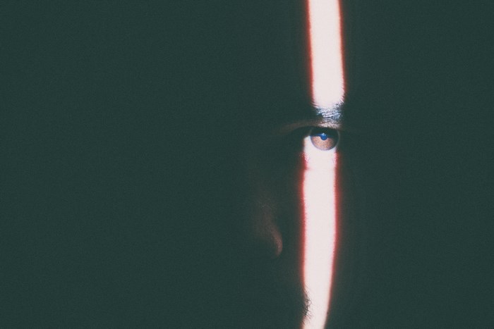 Man's eye illuminated by a vertical light beam