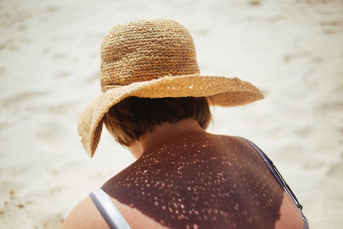 Woman wearing a straw hat on a sandy beach