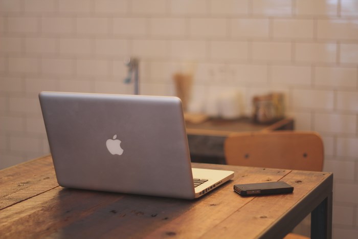 Apple MacBook Pro and smartphone on a wooden table