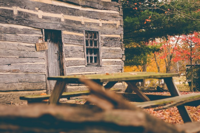 Rustic log cabin with picnic table in autumn