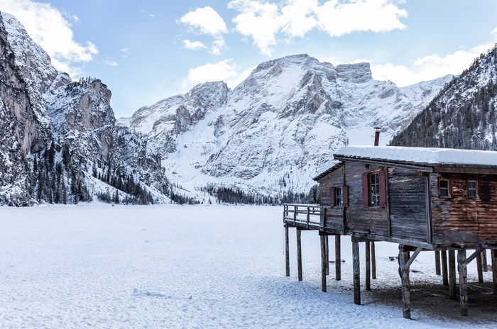 Wooden cabin on stilts in a snowy mountain landscape