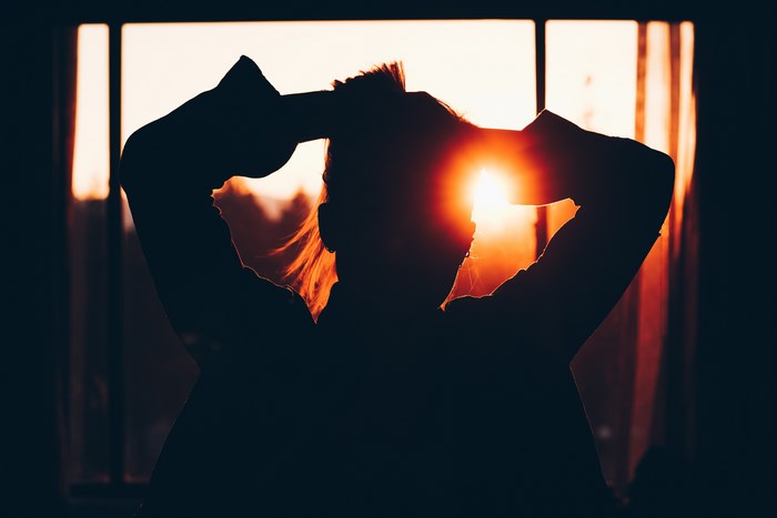 Silhouette of a woman with sun behind her