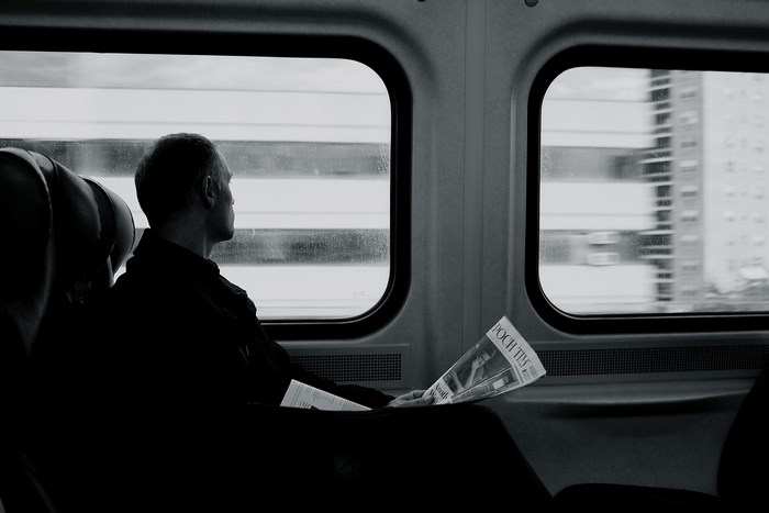 Man reading newspaper on a train