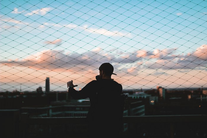 Man with camera looking at sunset over city