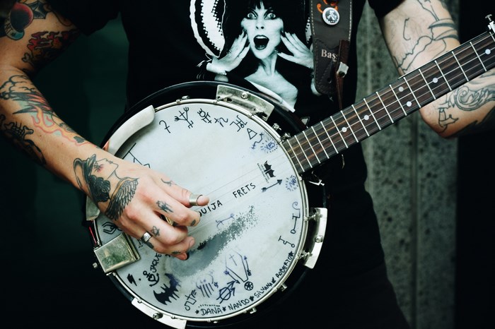 Man with tattoos playing a banjo