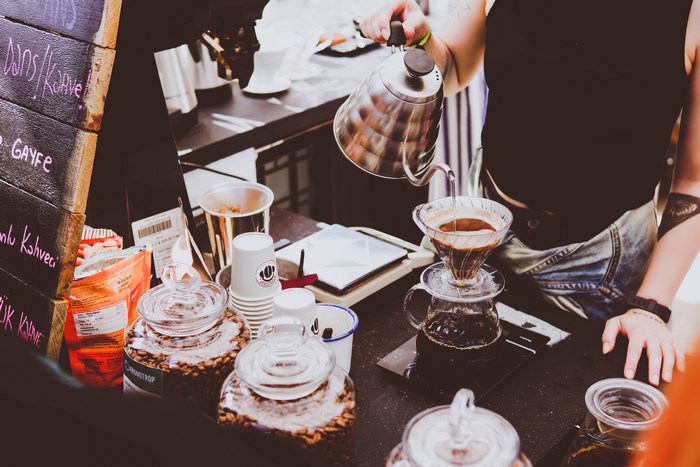Woman pouring coffee from a kettle into a filter