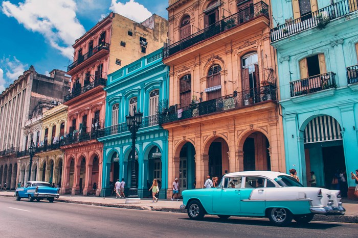 Colorful buildings and vintage cars on a street in Cuba