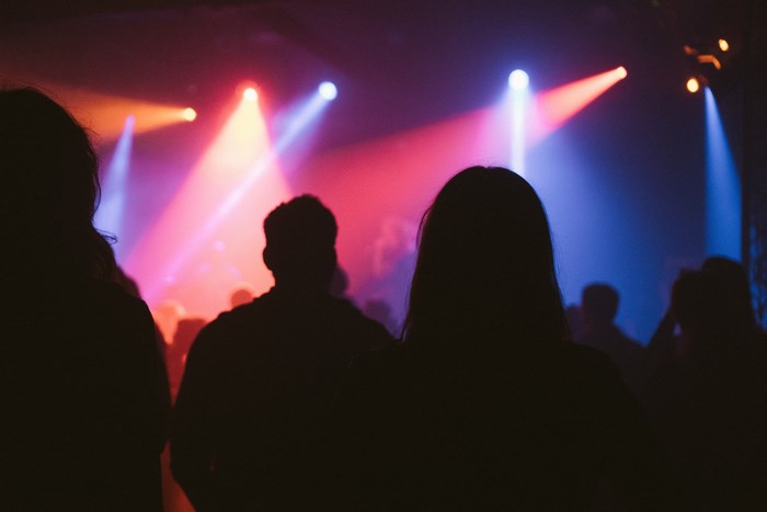 Crowd at a concert with colorful spotlights