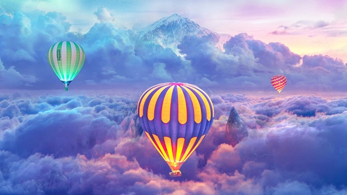 Hot air balloons floating above clouds with mountains