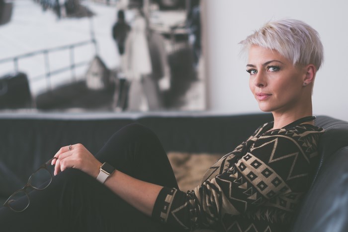 Woman with short blonde hair wearing a patterned sweater