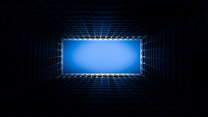 Looking up through a building's open roof at the sky