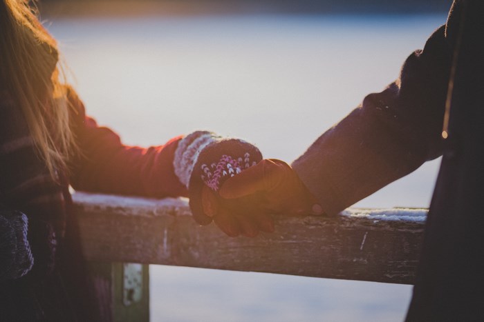 Couple holding hands outdoors during sunset