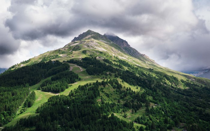 French Alps mountain landscape with green forests and clouds