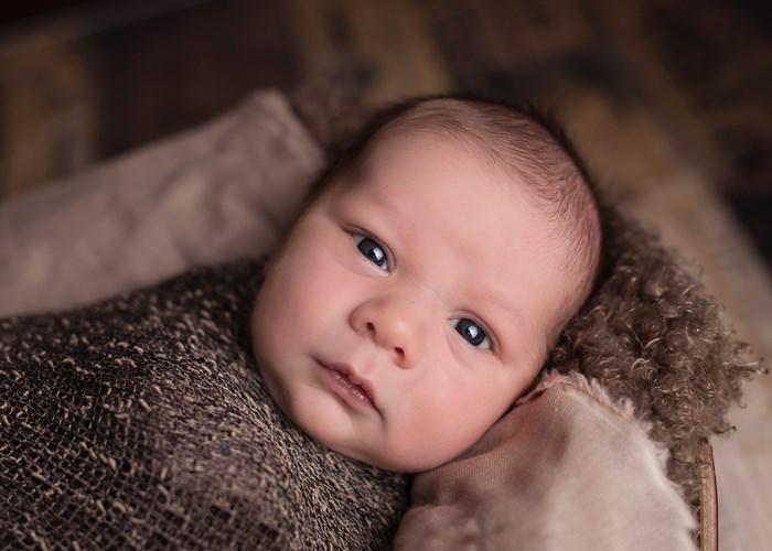 Newborn baby wrapped in brown blanket