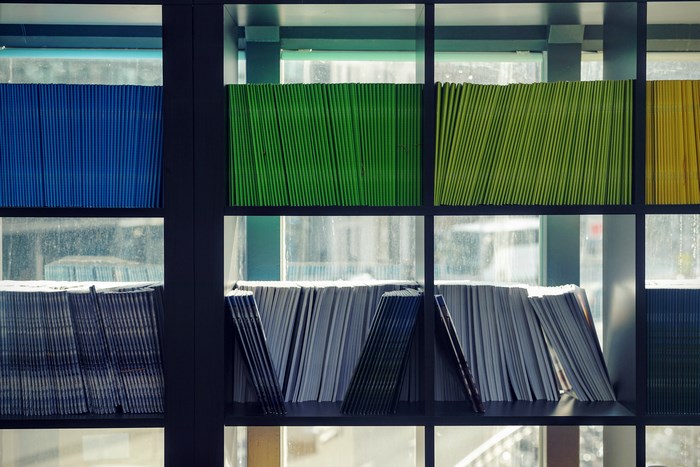Bookshelf with colorful files and magazines