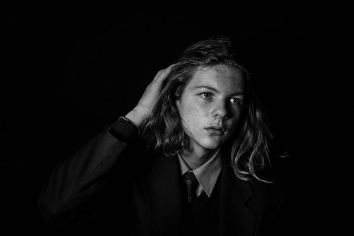 Teenage boy with long hair in a suit