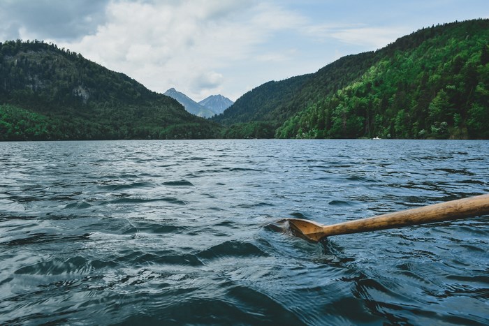 Rowing a boat on a lake surrounded by mountains