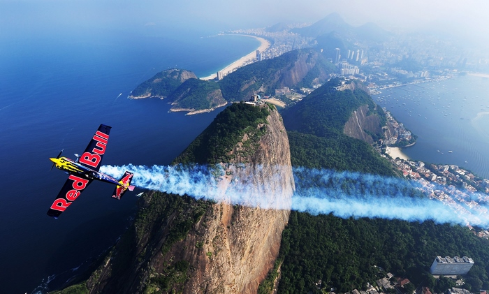 Red Bull airplane flying over Rio de Janeiro mountains